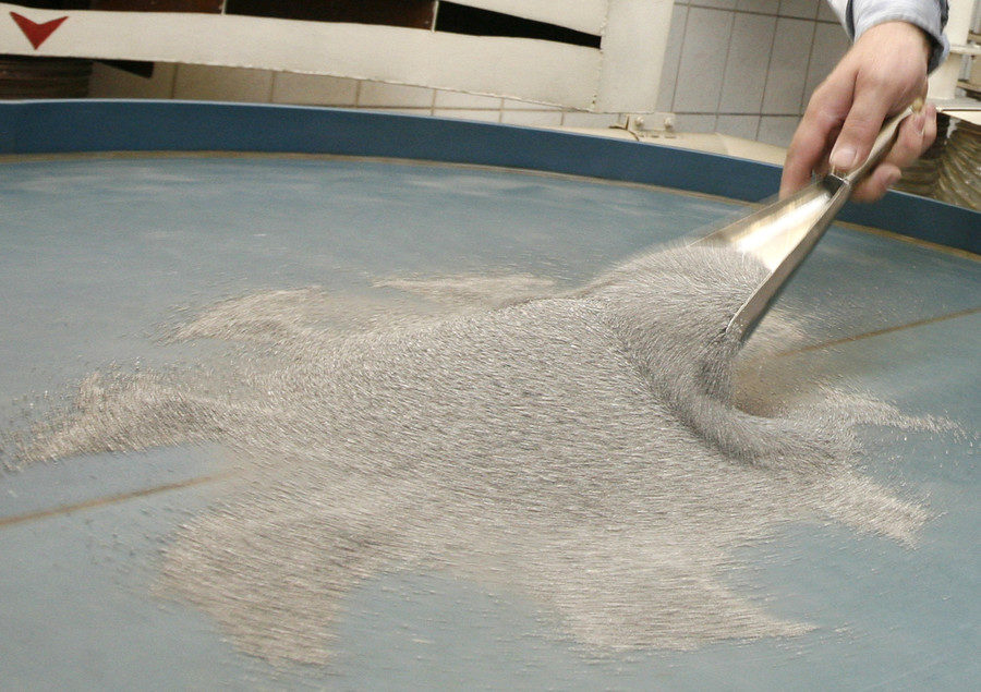 Click to enlarge A worker checks granules of palladium