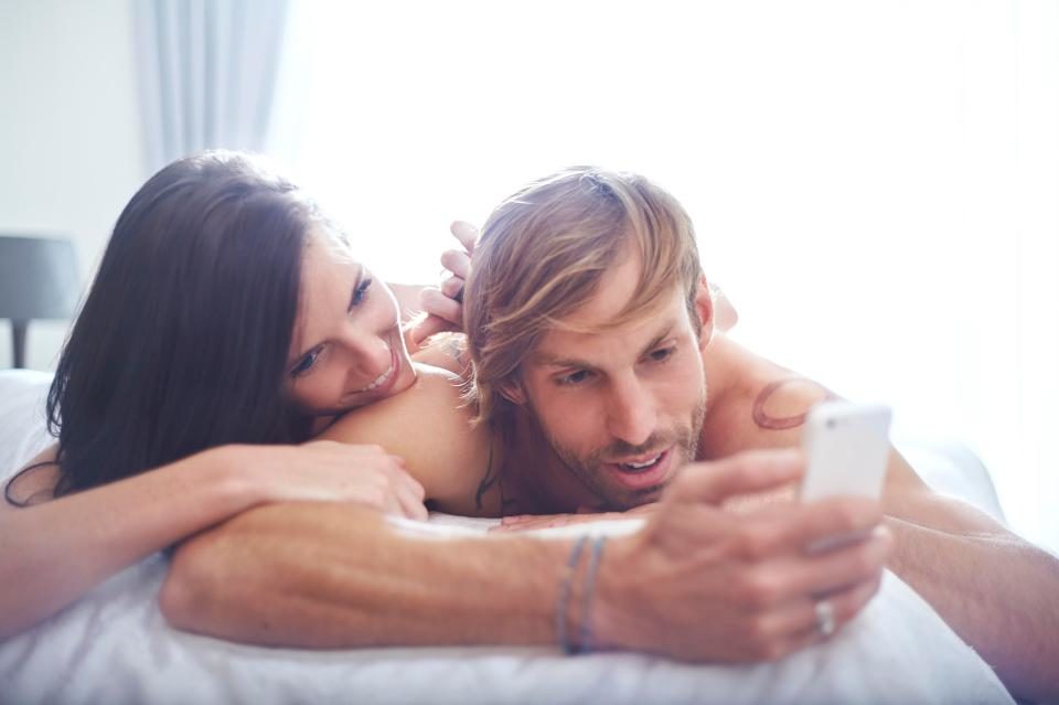 couple phone in bed