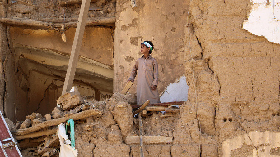 A boy stands on the rubble of a house in the city of Saada, Yemen
