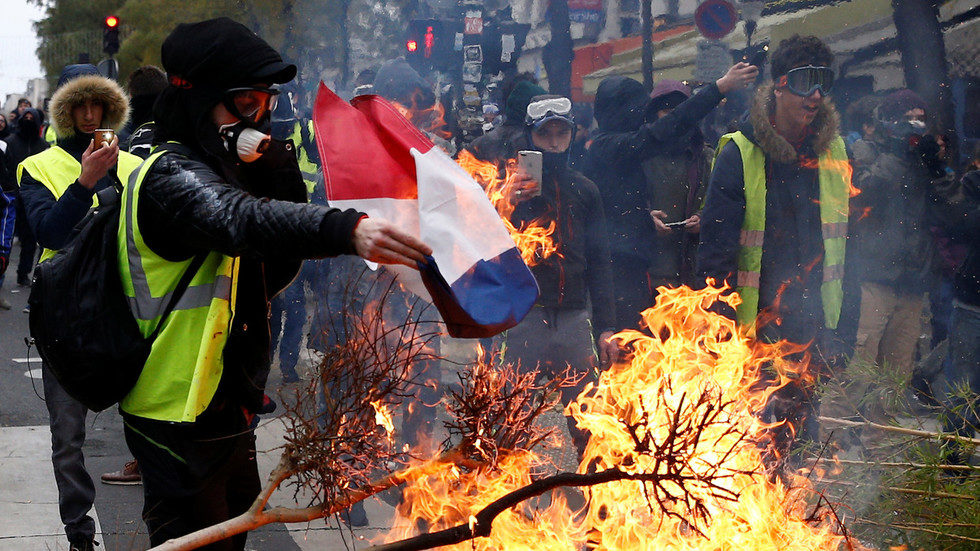 Protester burns French flag during Saturday's protest in Paris.