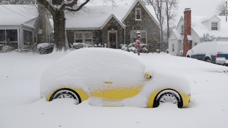 A snow-covered car sits outside a home Sunday in Greensboro, North Carolina.