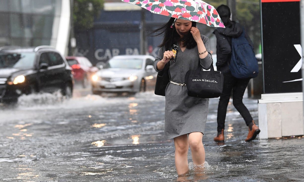 A pedestrian walks along a flooded street