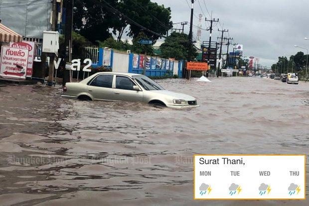 Vehicles crawl through a flooded road in Surat