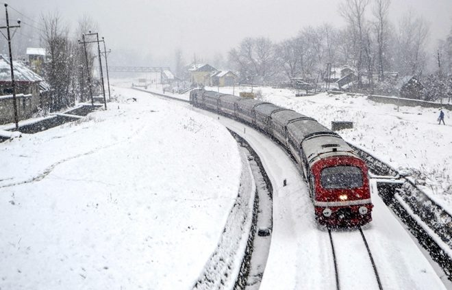 Anantnag: A train trails on a snow-covered Srinagar-Banihal railway track following fresh snowfall.
