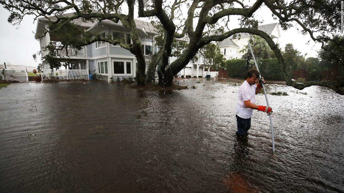 Mike Pollack searches for a drain in the yard of his flooded waterfront home a day after Hurricane Florence hit the area, on September 15, 2018 in Wilmington, North Carolina.