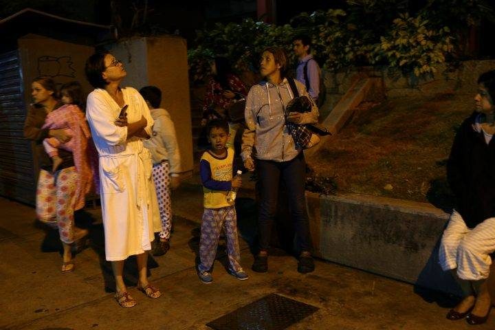 People stand on the street after an earthquake was felt across northern Venezuela