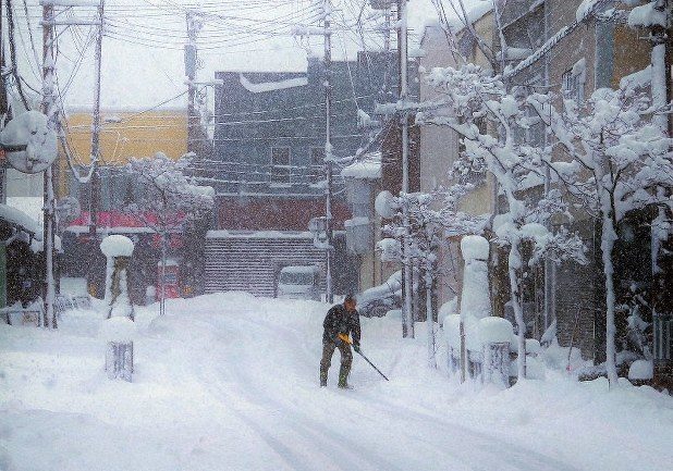A man shovels snow in the city of Yokote,