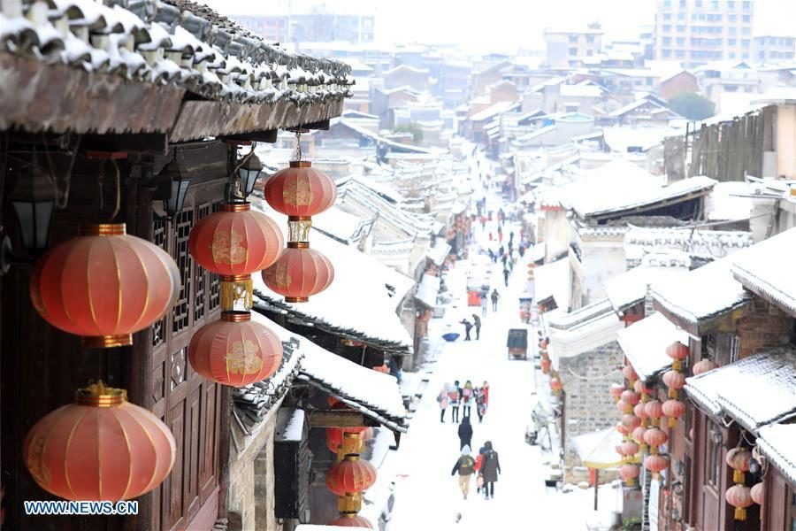 Tourists roam on a snow-covered ancient street