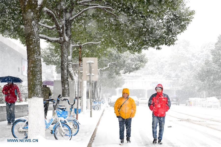 Pedestrians walk in snow in Changsha,