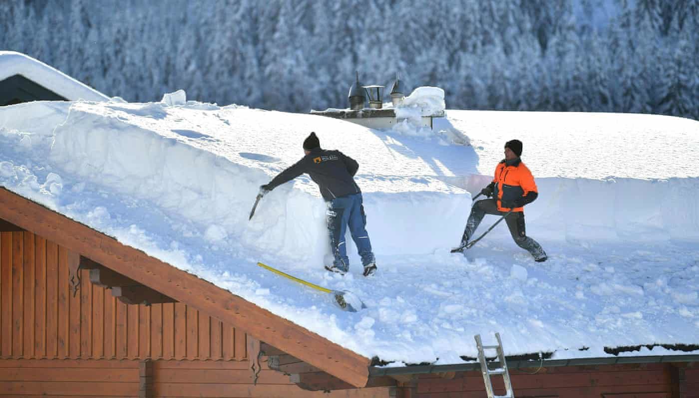 Men shovel snow from a roof in Untertauern, Austria