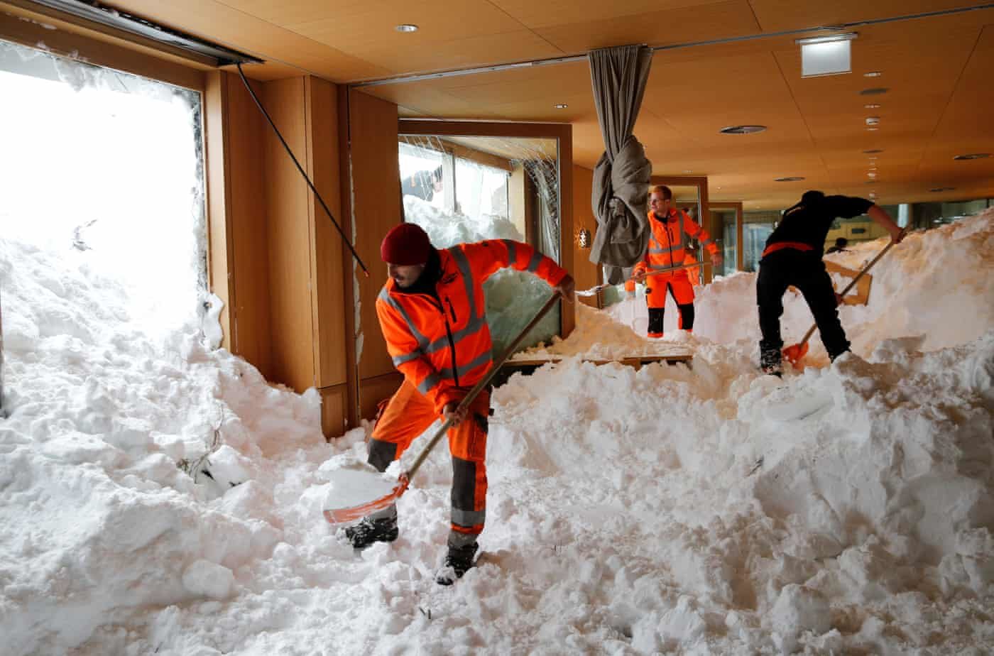 Click to enlarge Workers shovel snow out of a restaurant after