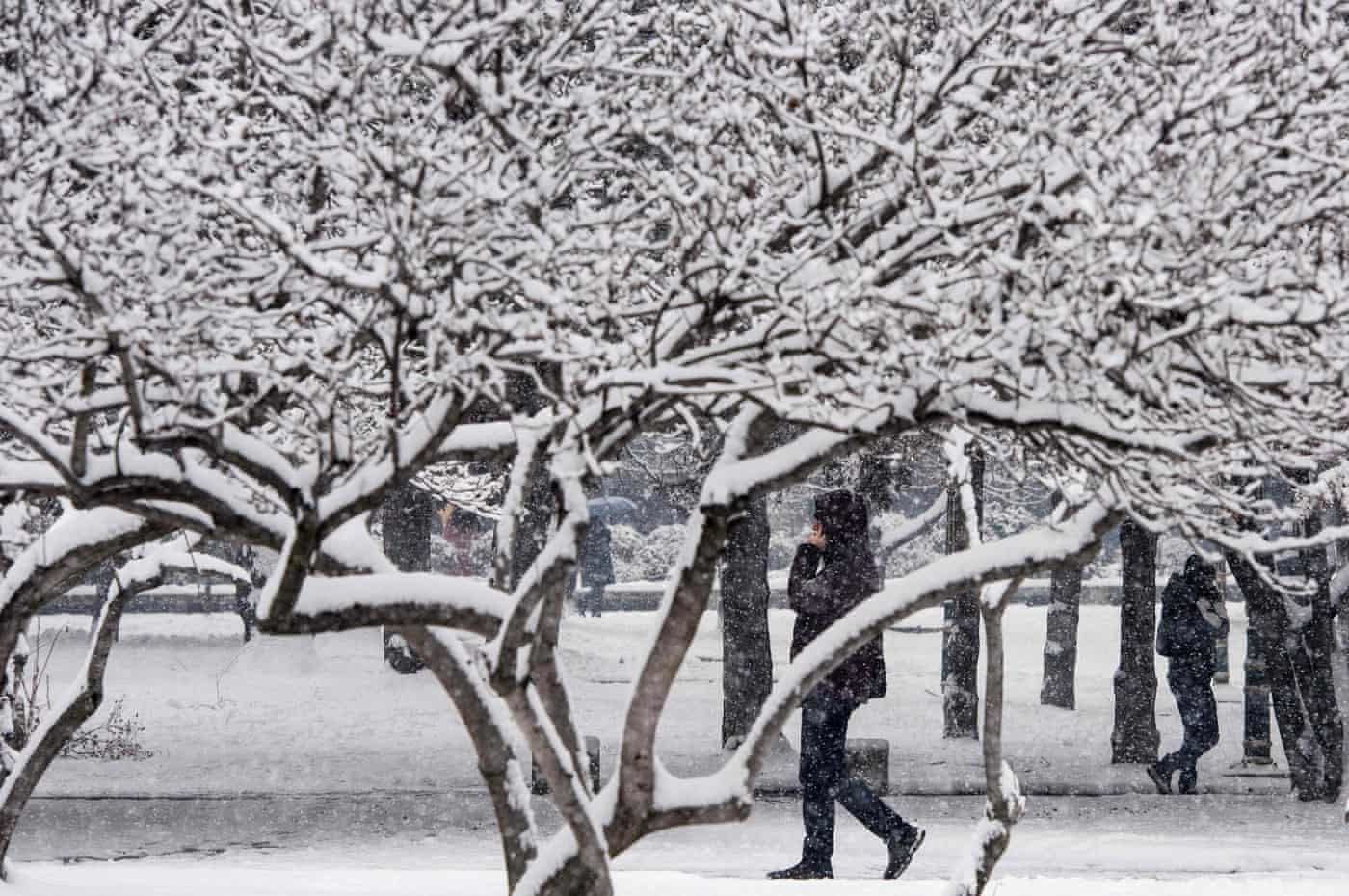 A man walks on a snow covered street during heavy snowfall in Skopje, Macedonia.