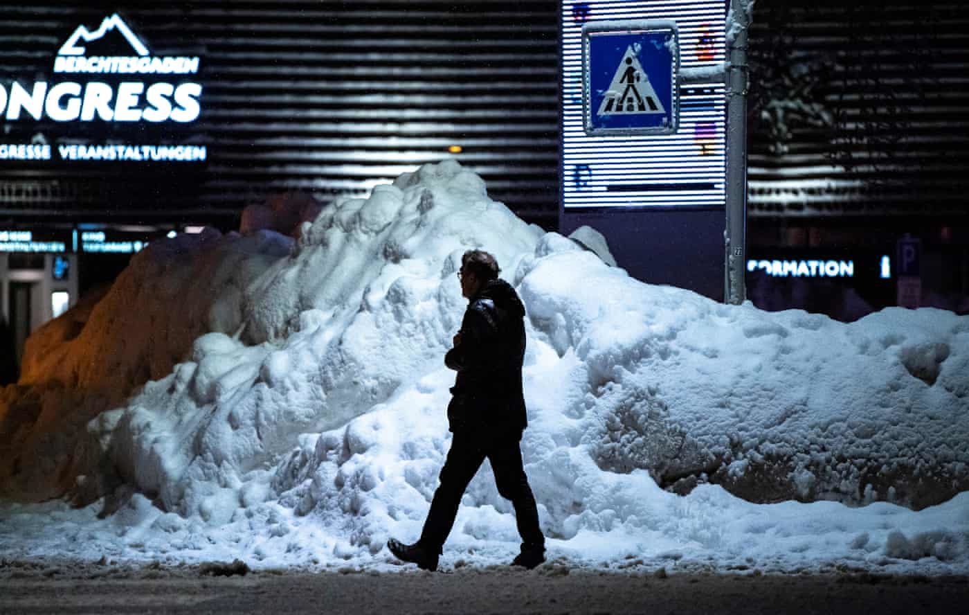 Click to enlarge A man walks past a pile of snow in the town centre of Berchtesgaden, Bavaria, Germany