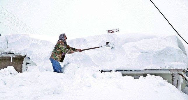 A man shovels snow from the roof of a house in the eastern city of Elazığ, Jan. 16, 2019.