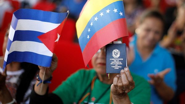 A supporter of Nicolas Maduro holding the flags of Cuba and Venezuela