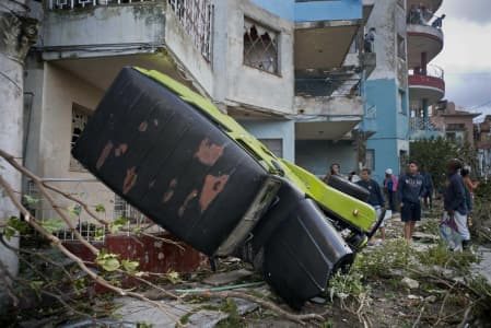 A truck is toppled against a home after a tornado in Havana, Cuba, Monday, Jan. 28, 2019