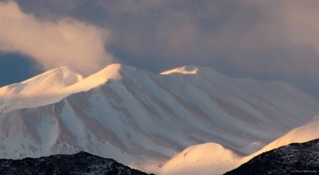 A thin layer of sand is seen atop the snow-covere