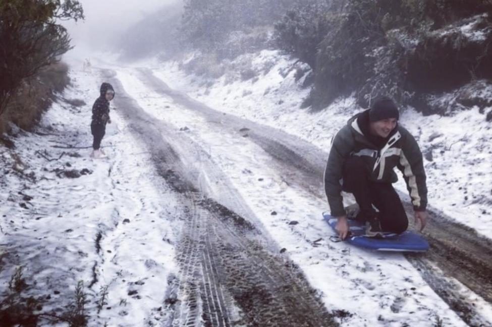 A family plays in the snow at Polipoli State Park in Hawaii