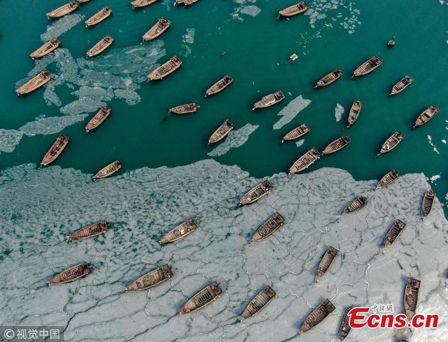 Boats are stranded in frozen sea at a port in Dalian City, Northeast China's Liaoning Province