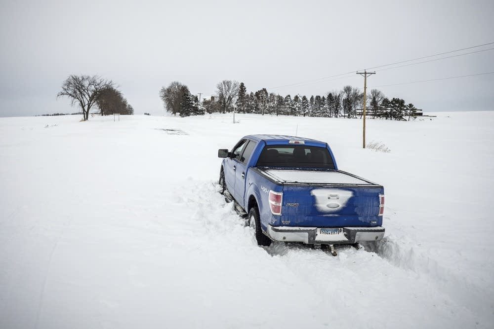 Rick Brewer, of Red Wing, Minn., sits in his pickup after getting stuck in drifted snow on U.S. Highway 63 Monday after heavy snow and winds over the weekend north of Zumbro Falls, Minn.