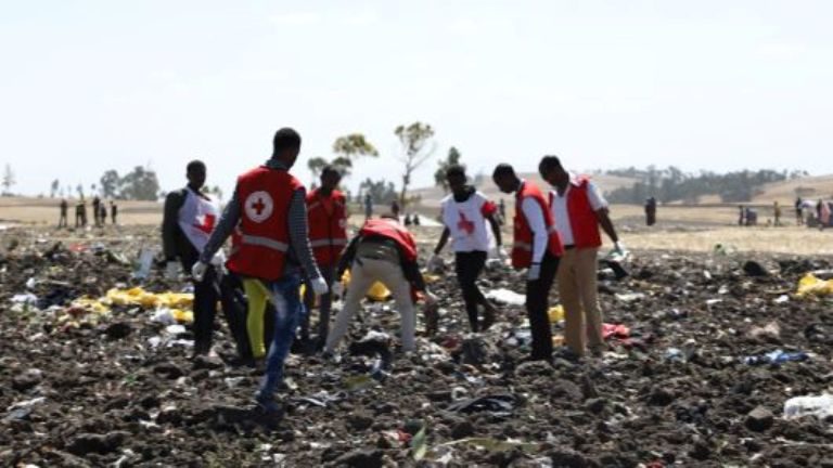 Emergency workers work amid debris at the crash site of Ethiopia Airlines