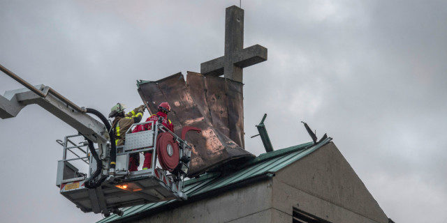 Click to enlarge Firefighters in Frankfurt try to secure the tin roof of a church tower in the district of Gallus