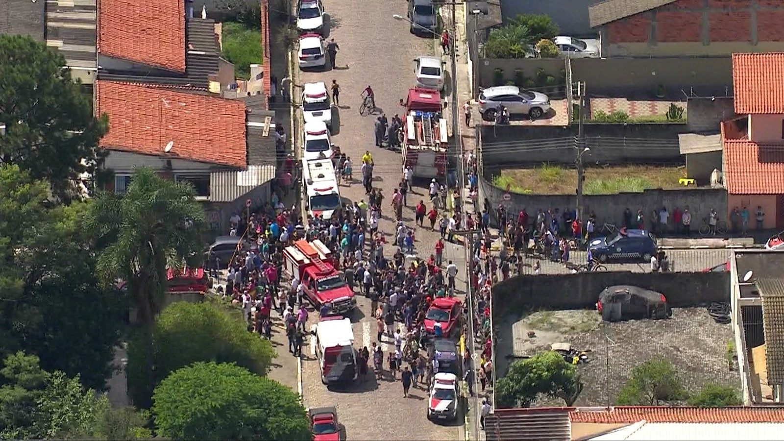 People gathered in front of Raul Brasil school, where students and teachers were killed