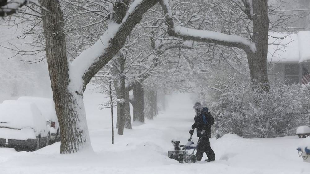 A person works on clearing snow during a winter storm Wednesday morning, March 13, 2019 in Casper, Wyo.