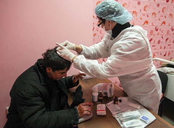 Click to enlarge Homeless person examined by a medic