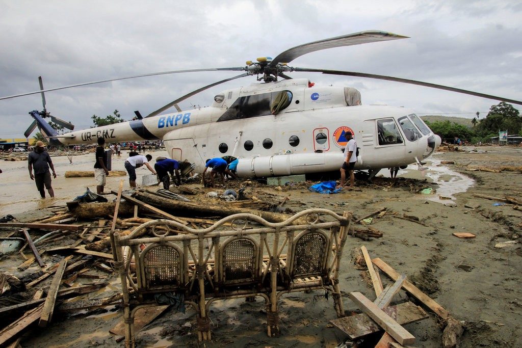 Click to enlarge Flash floods in Sentani, Papua, Indonesia, left debris and mud around a helicopter on Sunday.