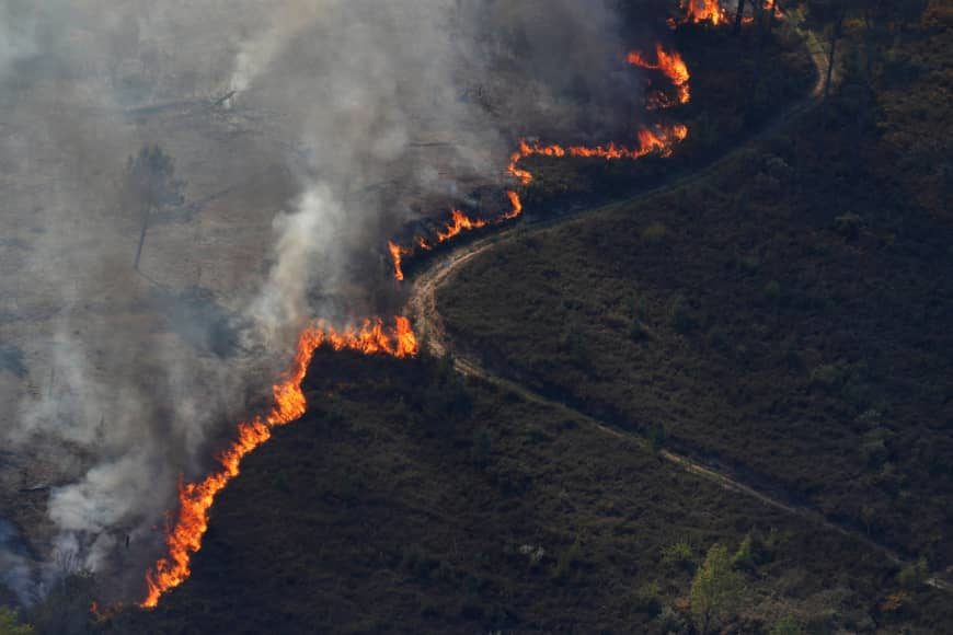 Click to enlarge Flames of an approaching forest fire are seen near the small village of Gondomil, near Valenca, Portugal, Wednesday