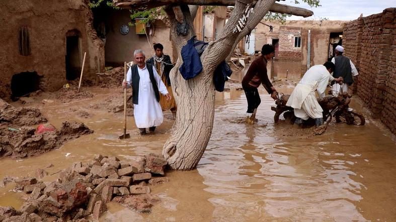 People salvage items from a house destroyed