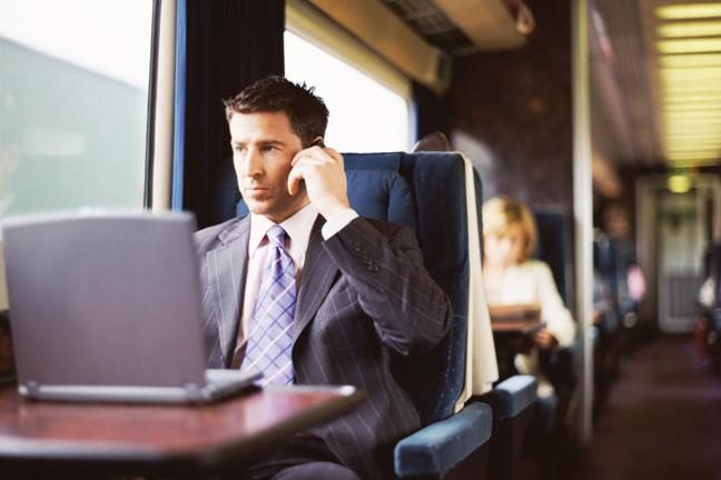 Businessman using train on phone