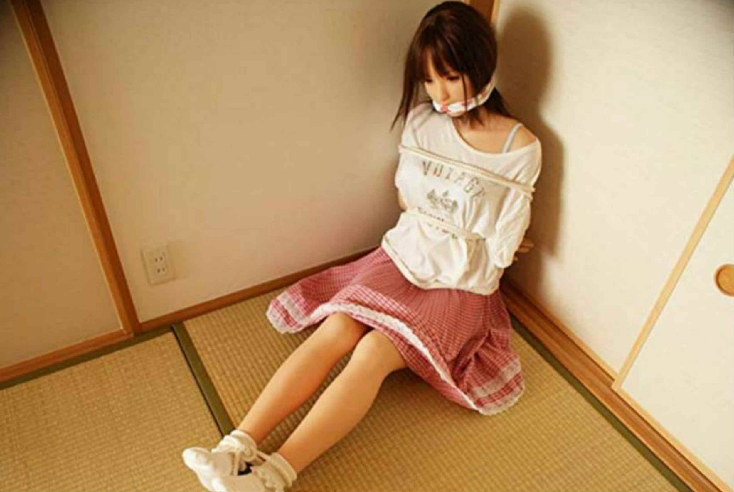 childlike doll of a woman gagged and tied up