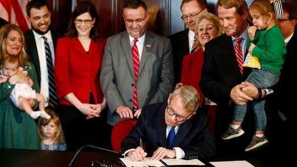 Click to enlarge Gov. Mike DeWine signs a bill