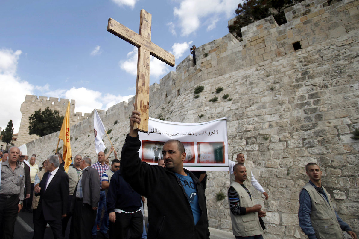 Click to enlarge Palestinian protester with cross