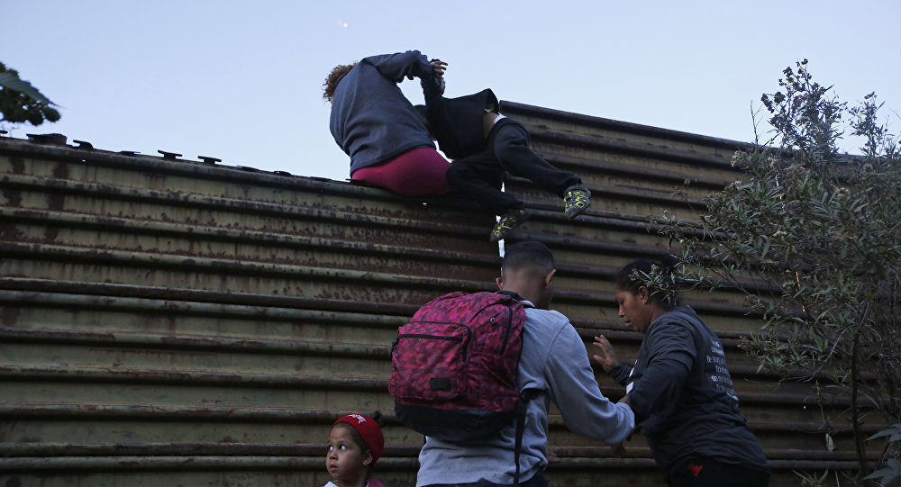 Click to enlarge migrants scale border wall mexico