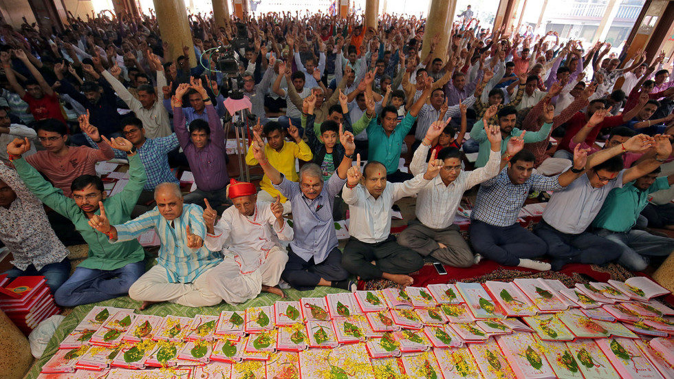 Indian businessmen pray in front of their record-keeping books in worship to the Hindu deity of wealth goddess Lakshmi