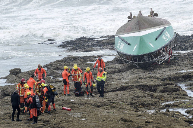 Rescue workers by the capsized boat in France