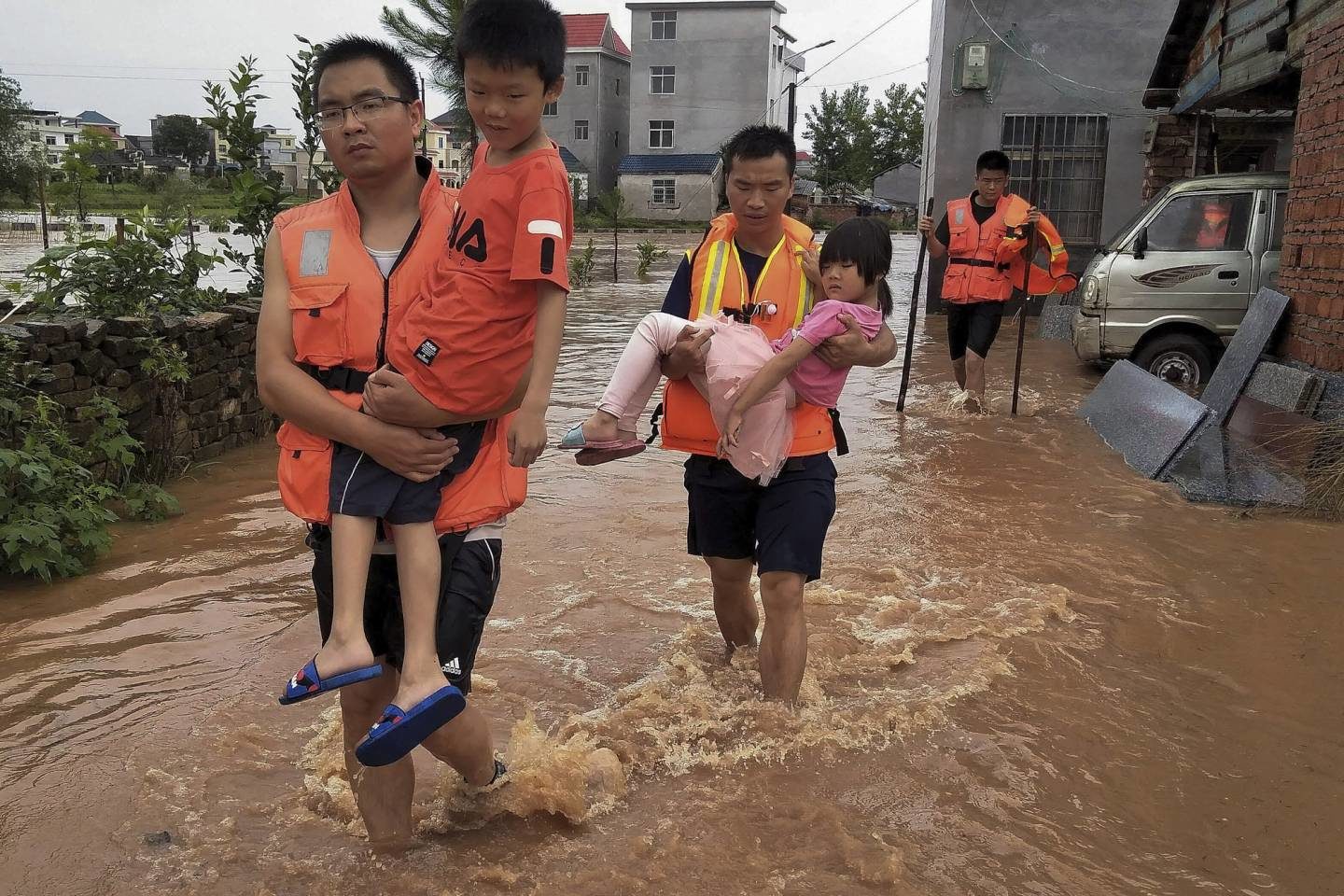 rescuers transfer children as the floods hit Xiangxing Township of Yongxin County in Ji'an City, east China's Jiangxi Province, Sunday, June 9, 2019.