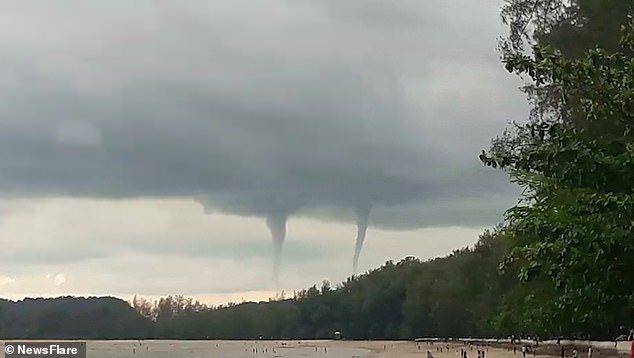 A double waterspout has occurred over a beach in Krabi, south Thailand, with two columns spinning from the water to the clouds