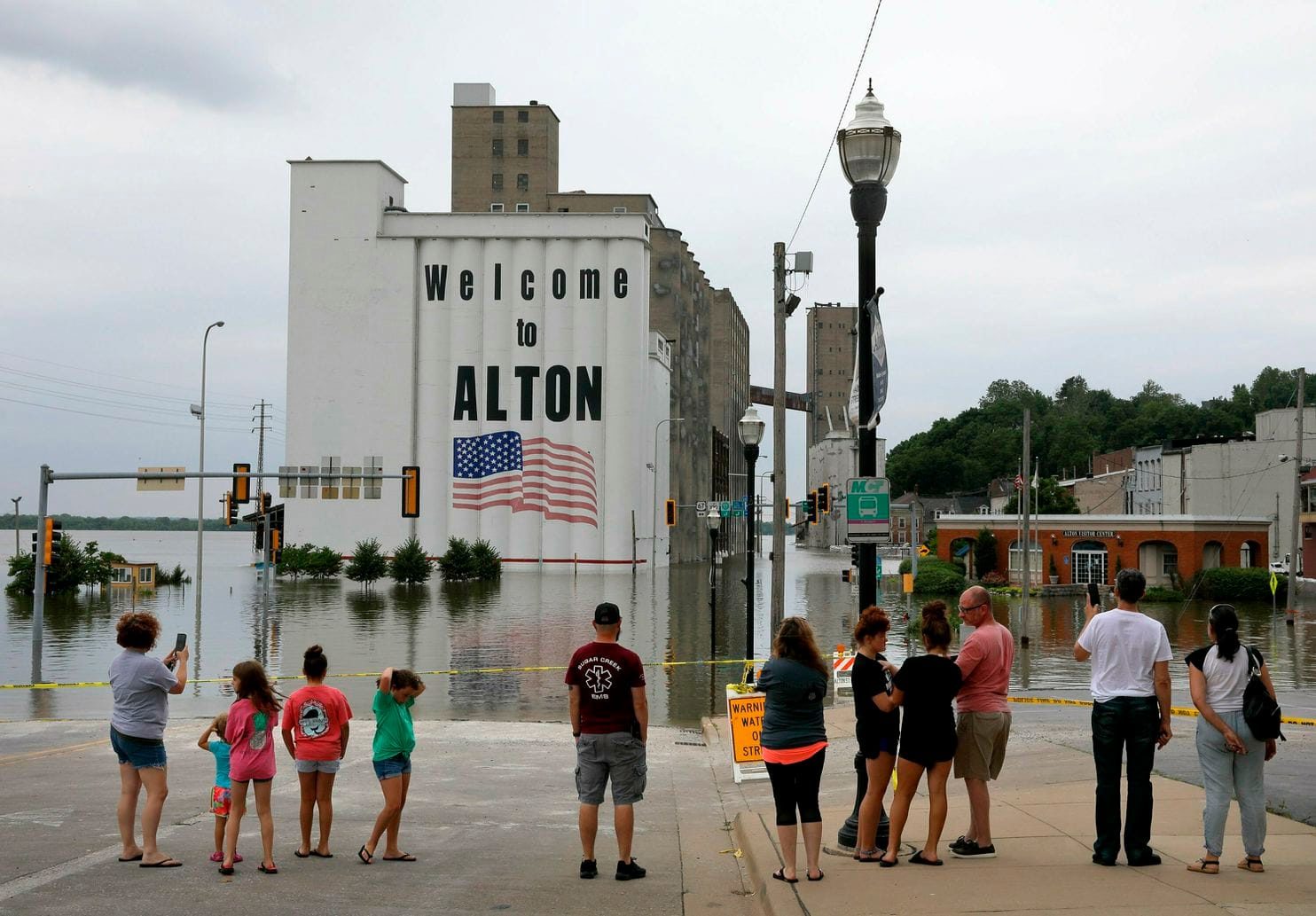 Click to enlarge People gather in downtown Alton, Ill. on Saturday as the Mississippi River there reached a level of 39 feet