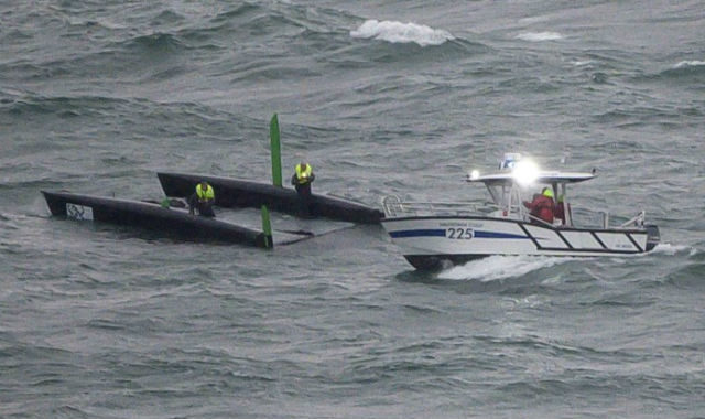 A police speedboat rescues a boat capsized after a massive storm during the Bol d'Or sailing race on Lake Geneva.