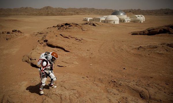A mock astronaut walks in the Gobi Desert