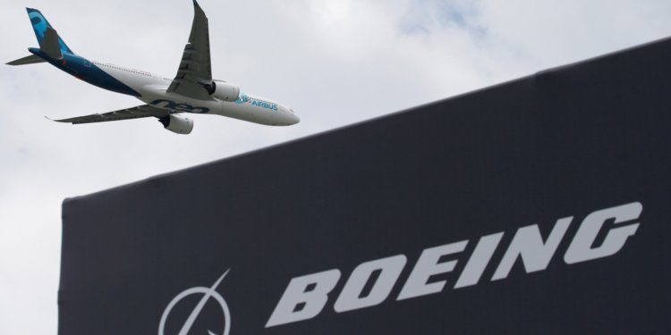 Click to enlarge An Airbus A330neo flying past a Boeing sign at the 2019 International Paris Air Show.