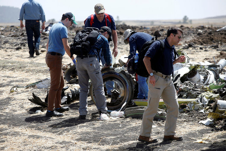 American civil aviation and Boeing investigators searching through the debris