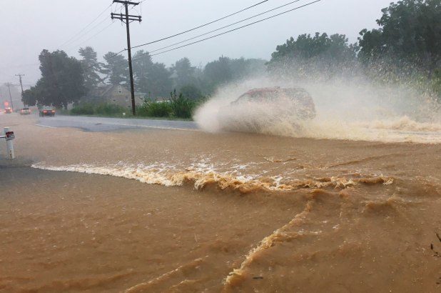 A vehicle goes through flooded Route 562 near Boyertown, PA.