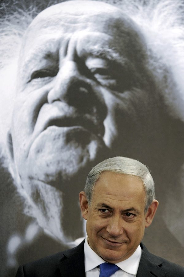 Benjamin Netanyahu sits in front of a picture of David Ben-Gurion