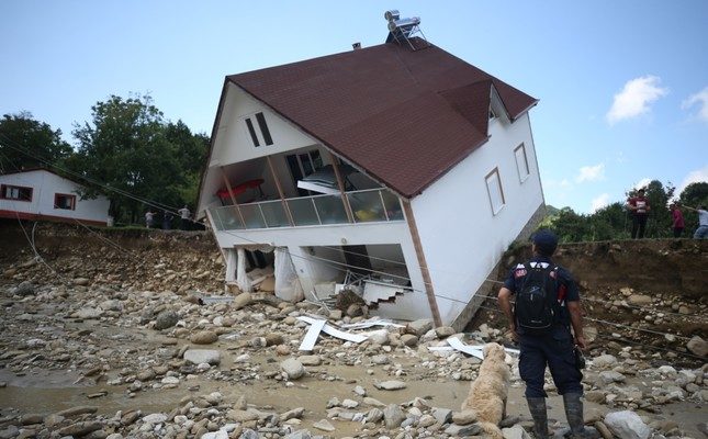 A gendarmerie personnel looks at a house tipped over due to floods in Esmahanım village, Düzce, July 19, 2019.