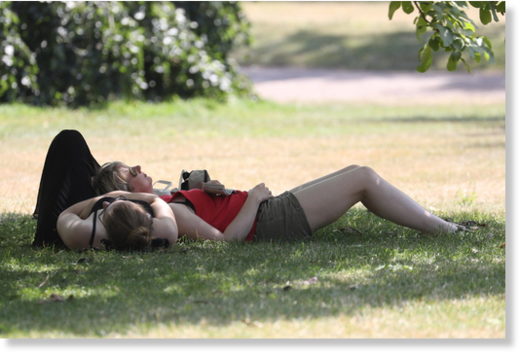People lie in a park under 30+ degrees Celsius in London, July 25th 2019